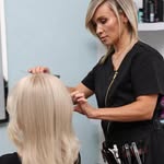Kadeřnice pracuje s blond vlasy klientky